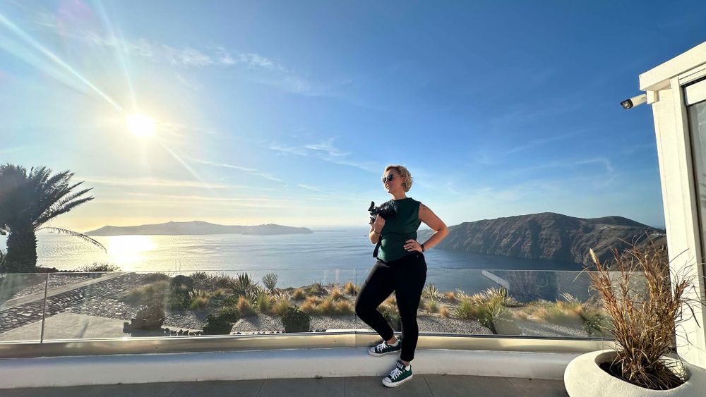 A person jogs on a hillside patio with stunning coastal mountain views and bright sunshine overhead.