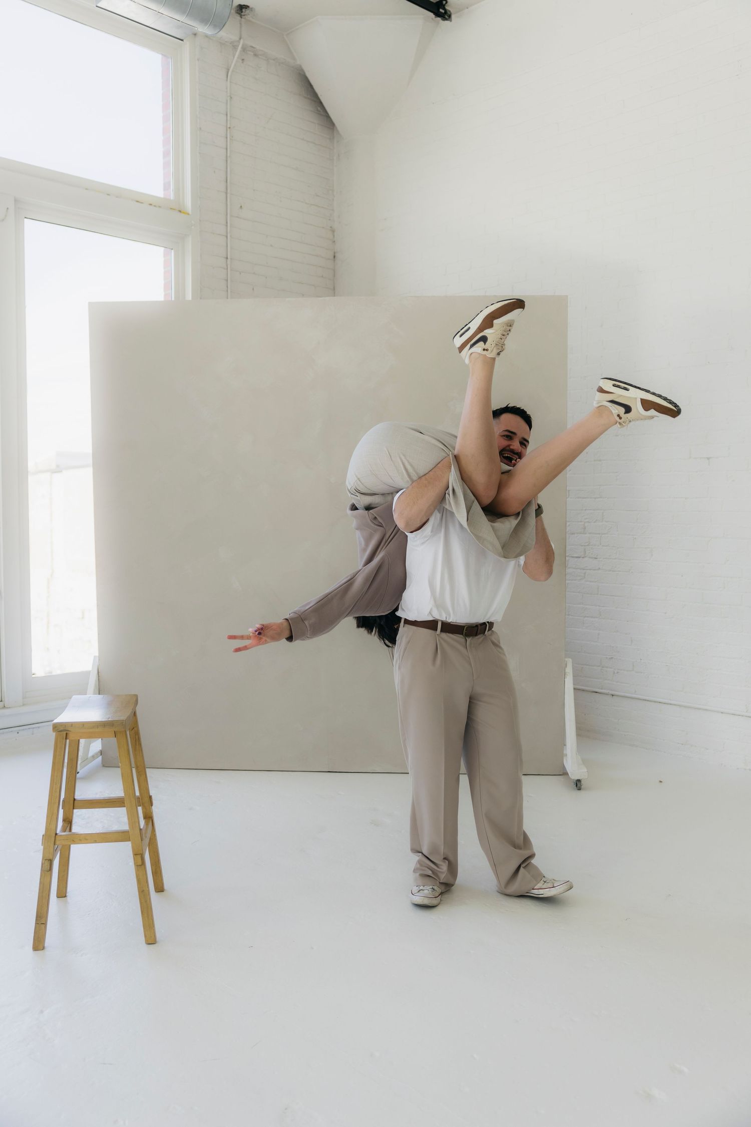 A playful studio photo shoot with someone being lifted in the air.
