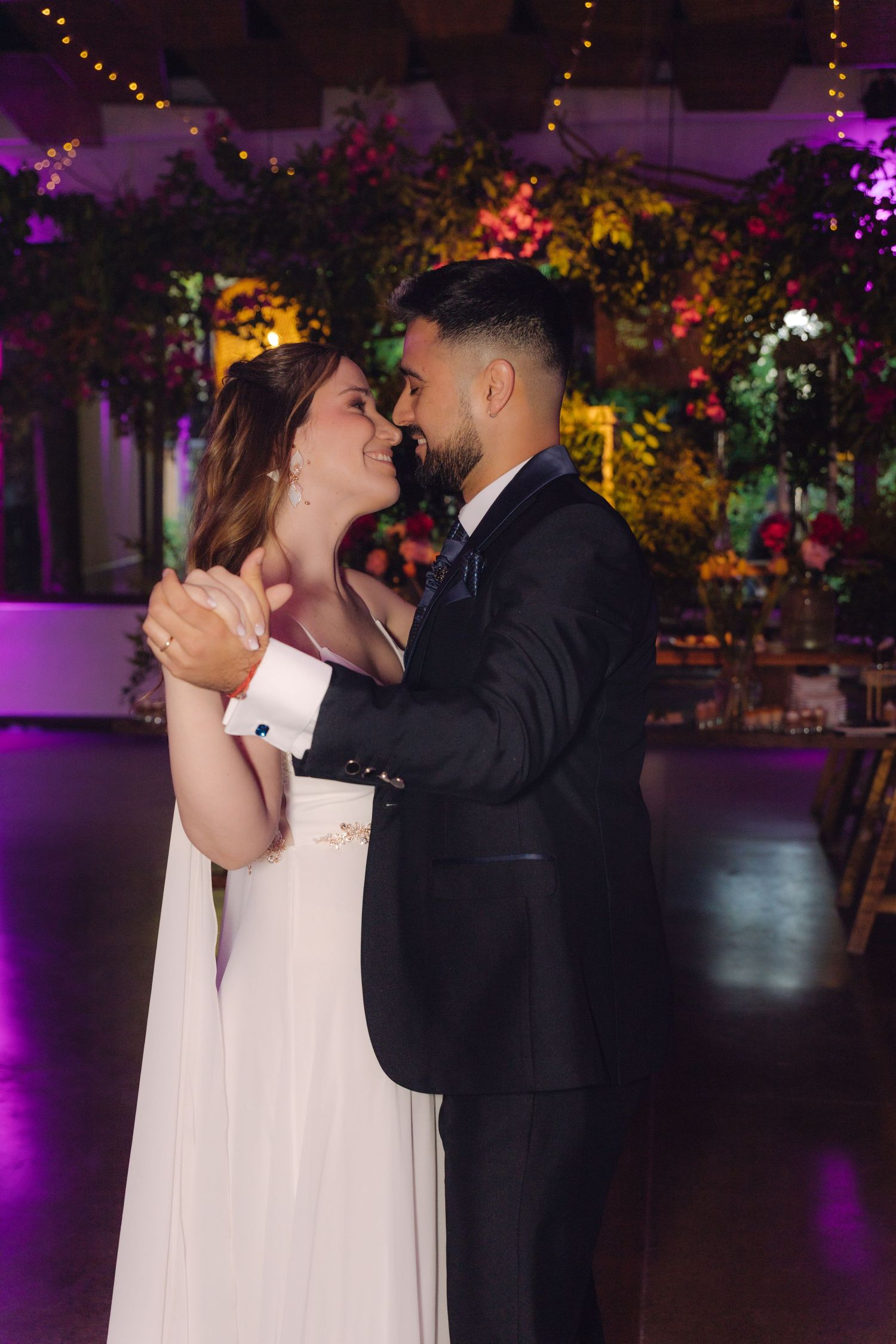 Bride and groom share their first dance in a beautifully decorated indoor wedding reception.