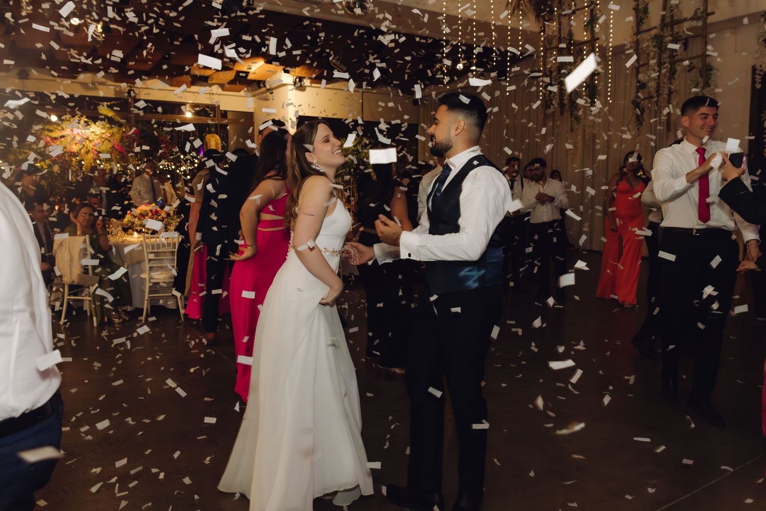 Couple shares romantic first dance as confetti fills the air at their wedding reception.