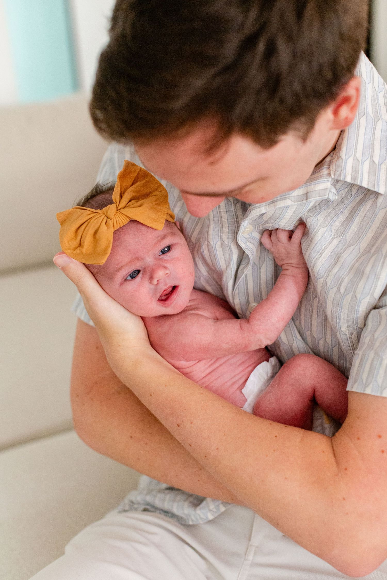 Portrait of a newborn in her father's arms. In-home lifestyle newborn session in Guaynabo, Puerto Rico.