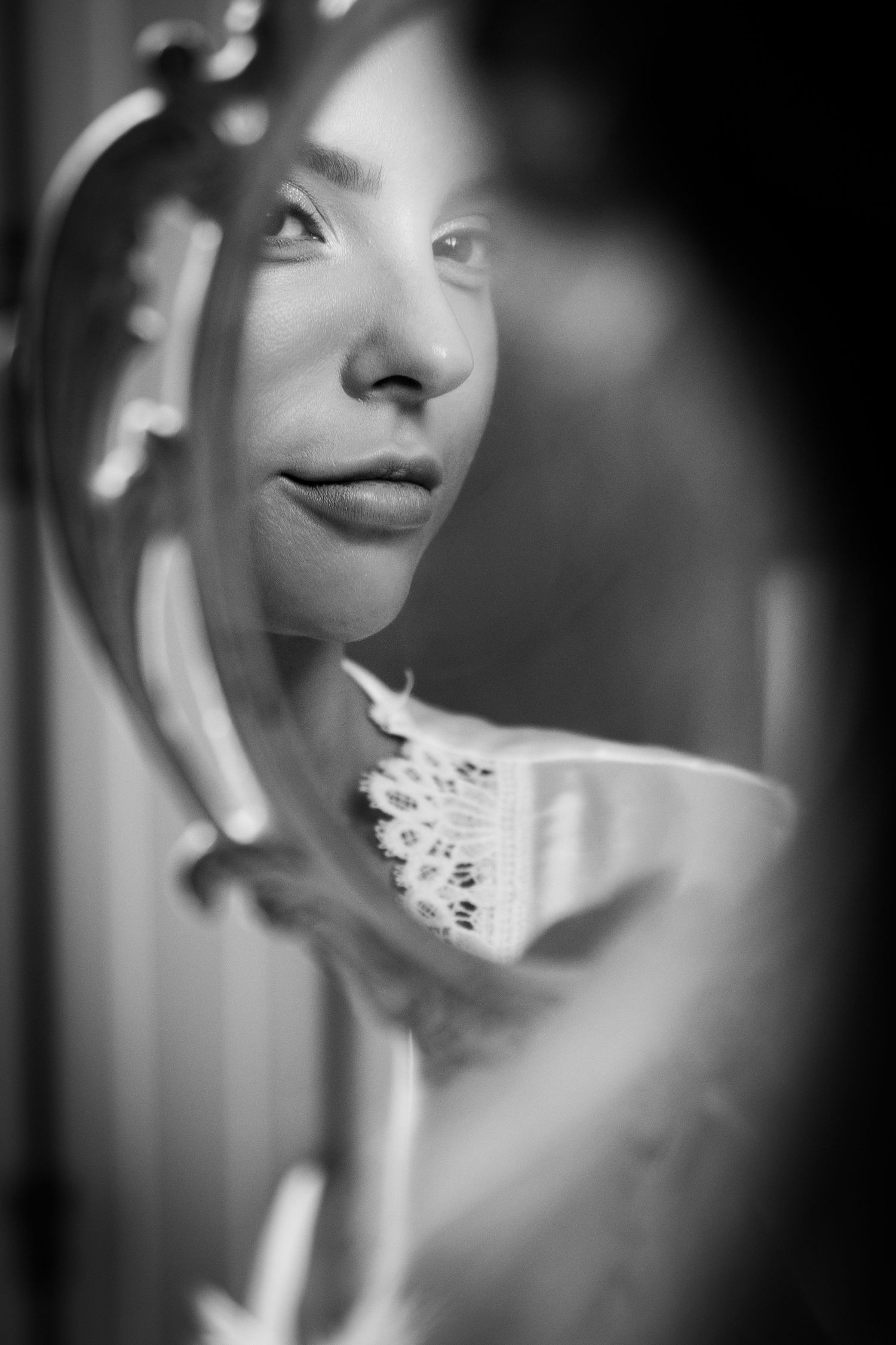 Silhouette of a bride in wedding gown standing before louvered shuttered doors in dramatic lighting.
