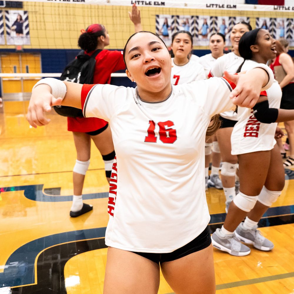 Excited volleyball player number 16 in white and red uniform celebrating victory on court.