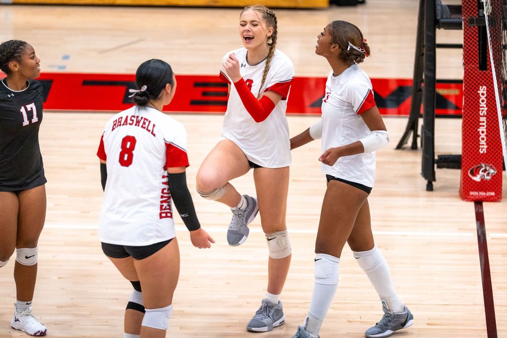 Braswell volleyball players celebrate a point during a high school match on the home court.