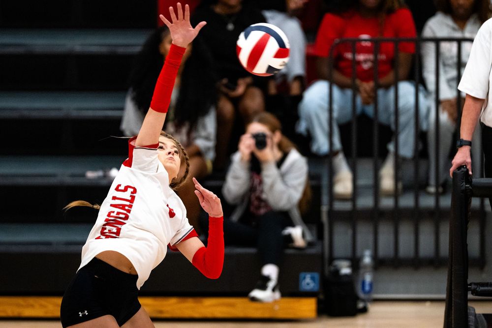 A Bengals volleyball player leaps to spike the ball during a competitive high school match.