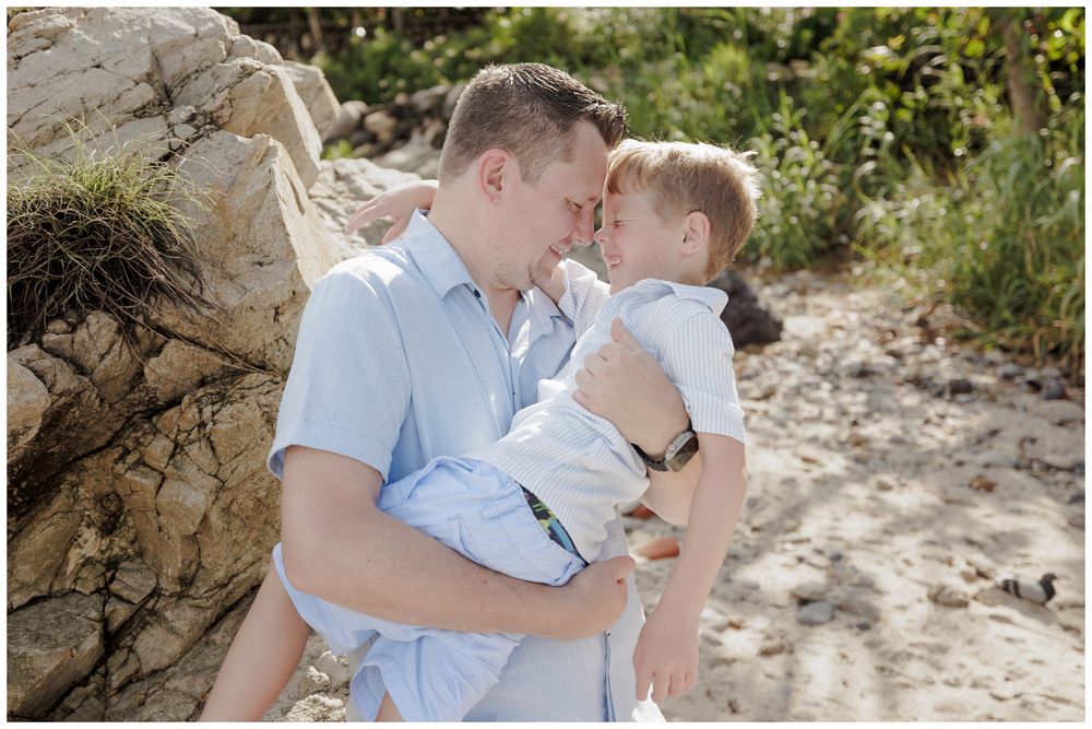 Family Beach Photos at Conchas Chinas Beach in Puerto Vallarta with a father tenderly holding his young son in a warm, intimate moment.