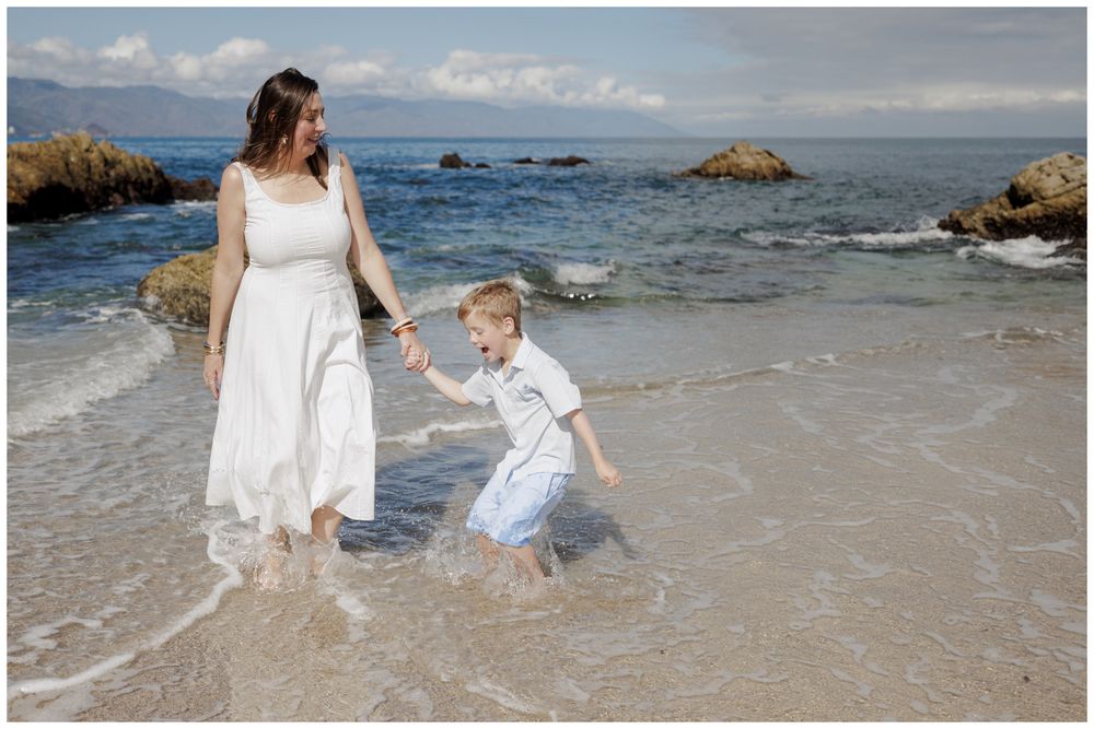 Family Vacation Photos at Conchas Chinas Beach in Puerto Vallarta with a mother and her son playing together in the sunny ocean waves.
