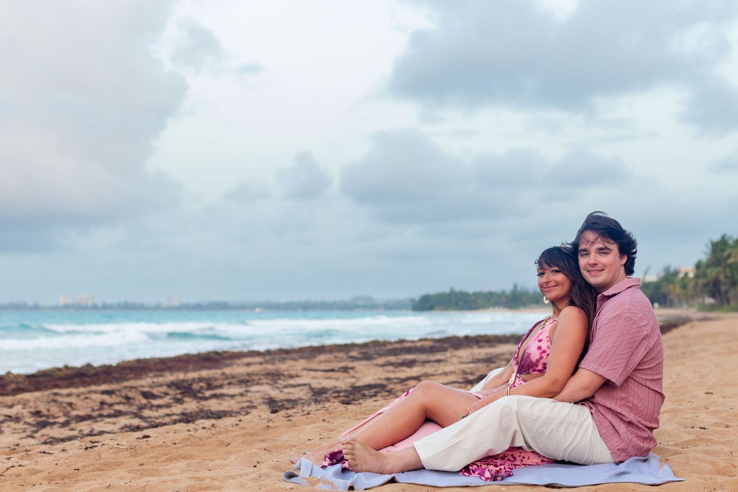 Couples portrait on the beach. Seated on a blanket. Río Grande, Puerto Rico.