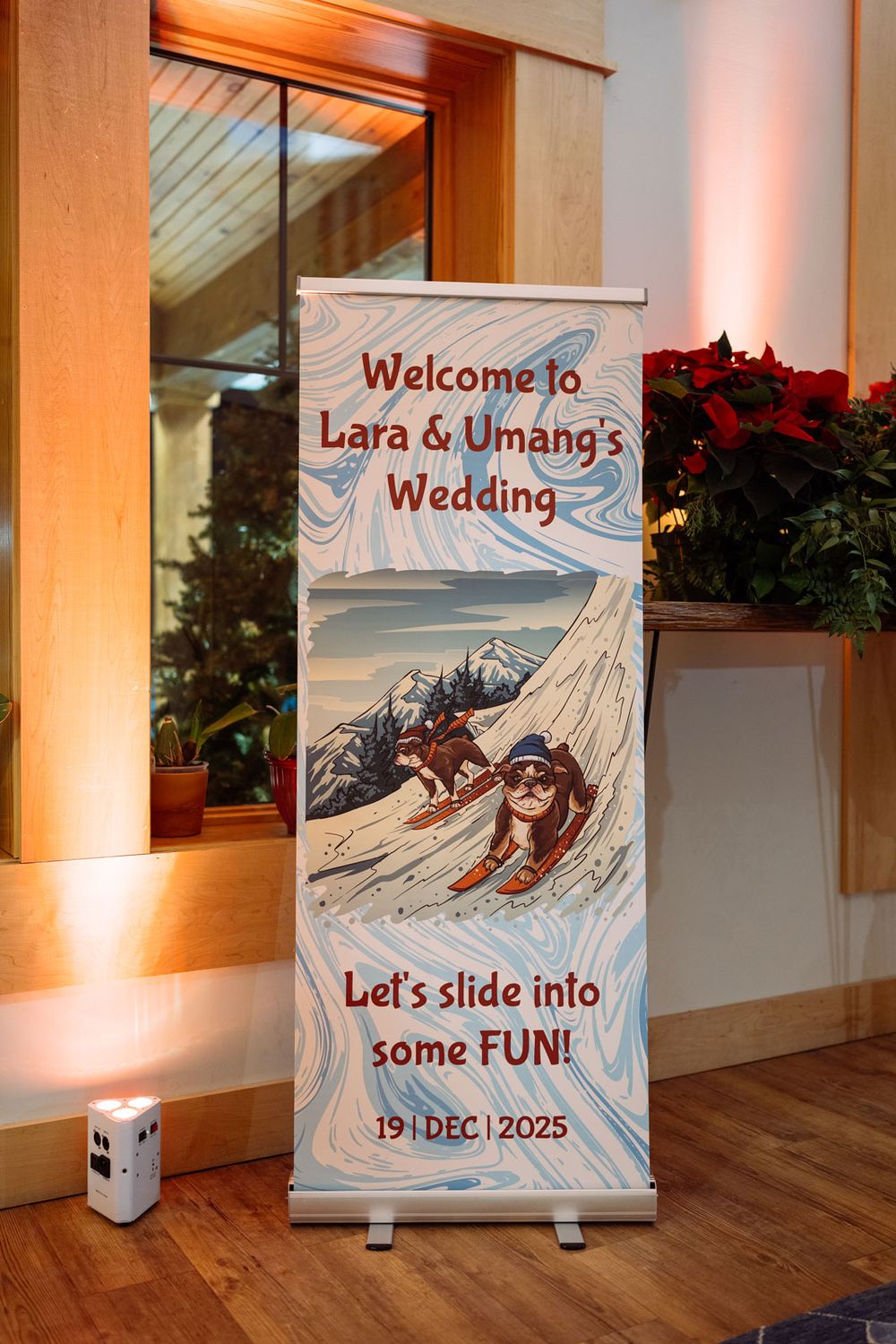 Wedding welcome banner for Lara & Umang's ski-themed wedding on Dec 19, 2025, featuring cartoon skiers and fun typography.