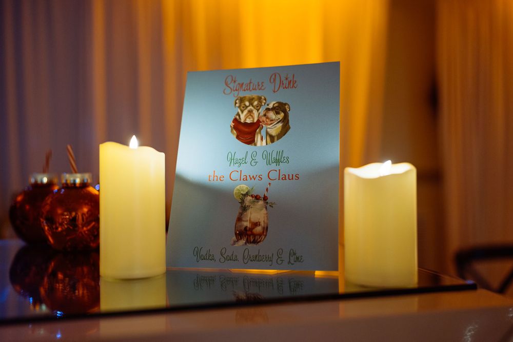 A holiday book titled Santa's Dolls flanked by glowing white candles and red ornaments in warm festive lighting.
