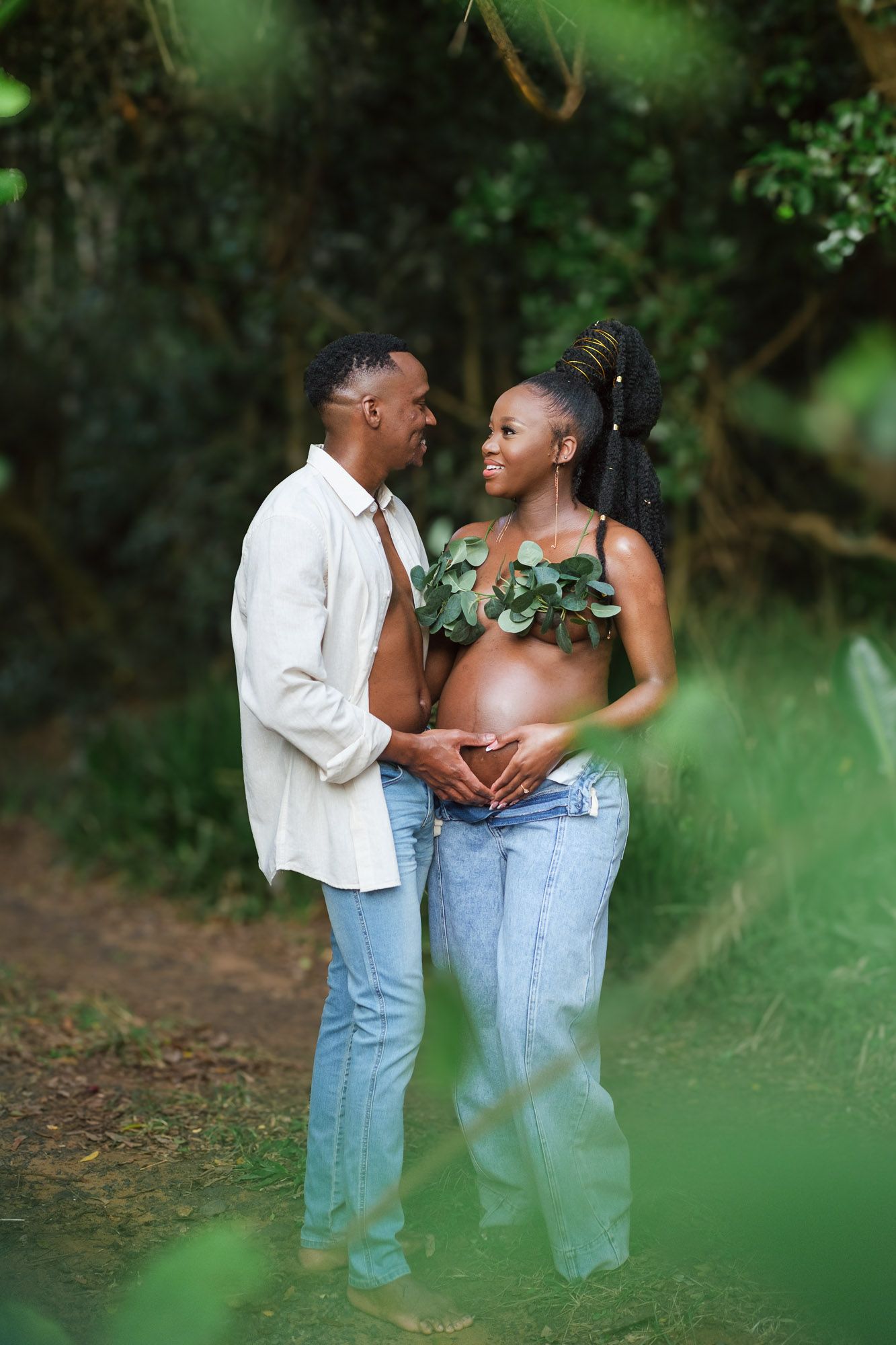 Maternity couple surrounded by beautiful forest scenery during their pregnancy photoshoot
