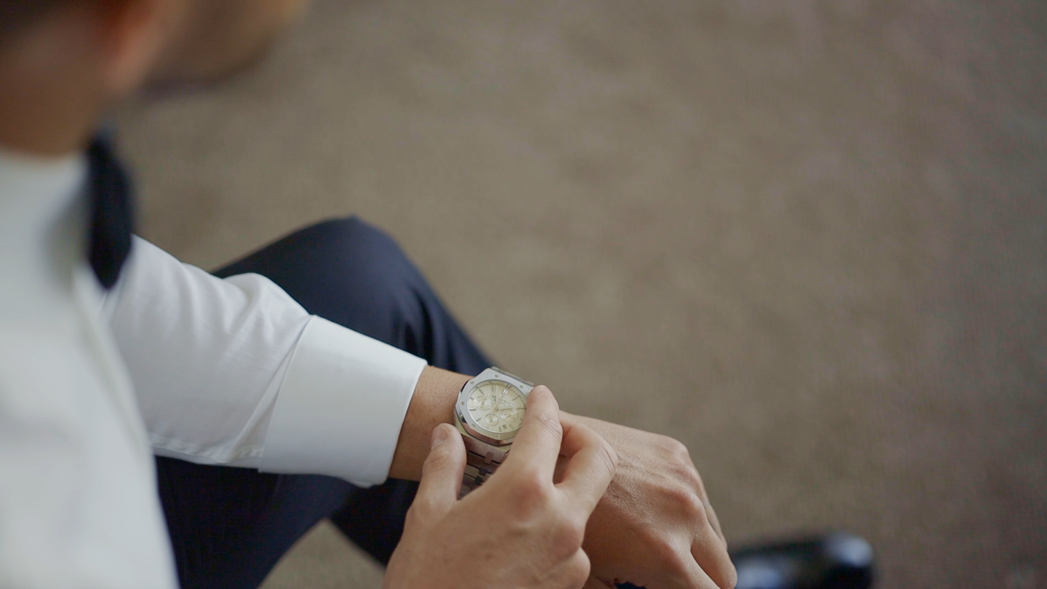 Groom fastening his cufflinks before walking down the aisle.