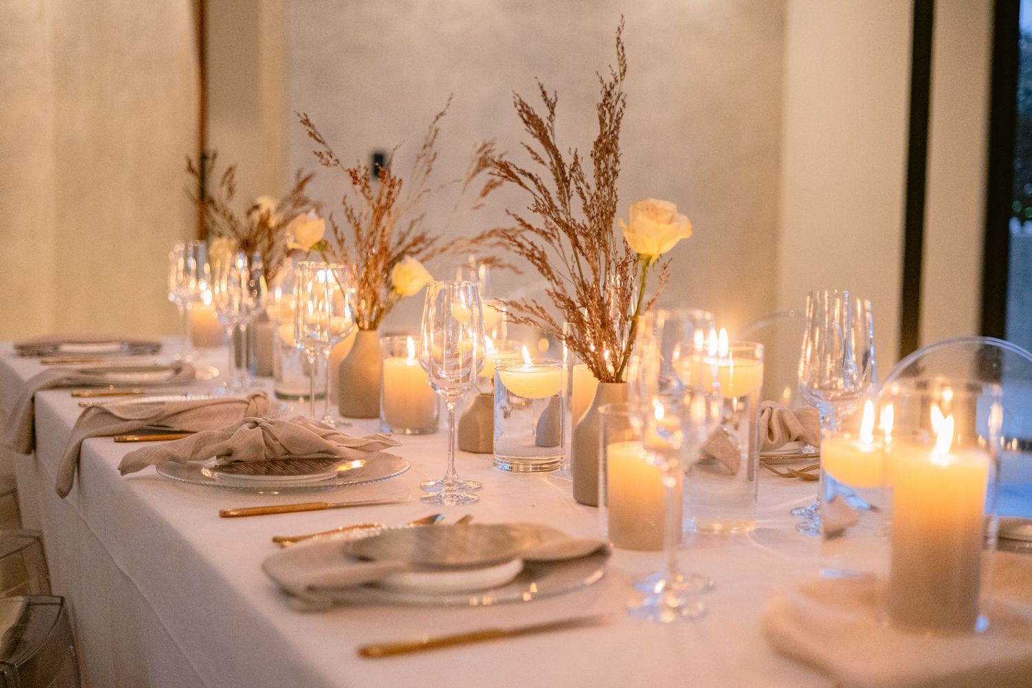 Wedding reception hall decorated with elegant tables and hanging lights.