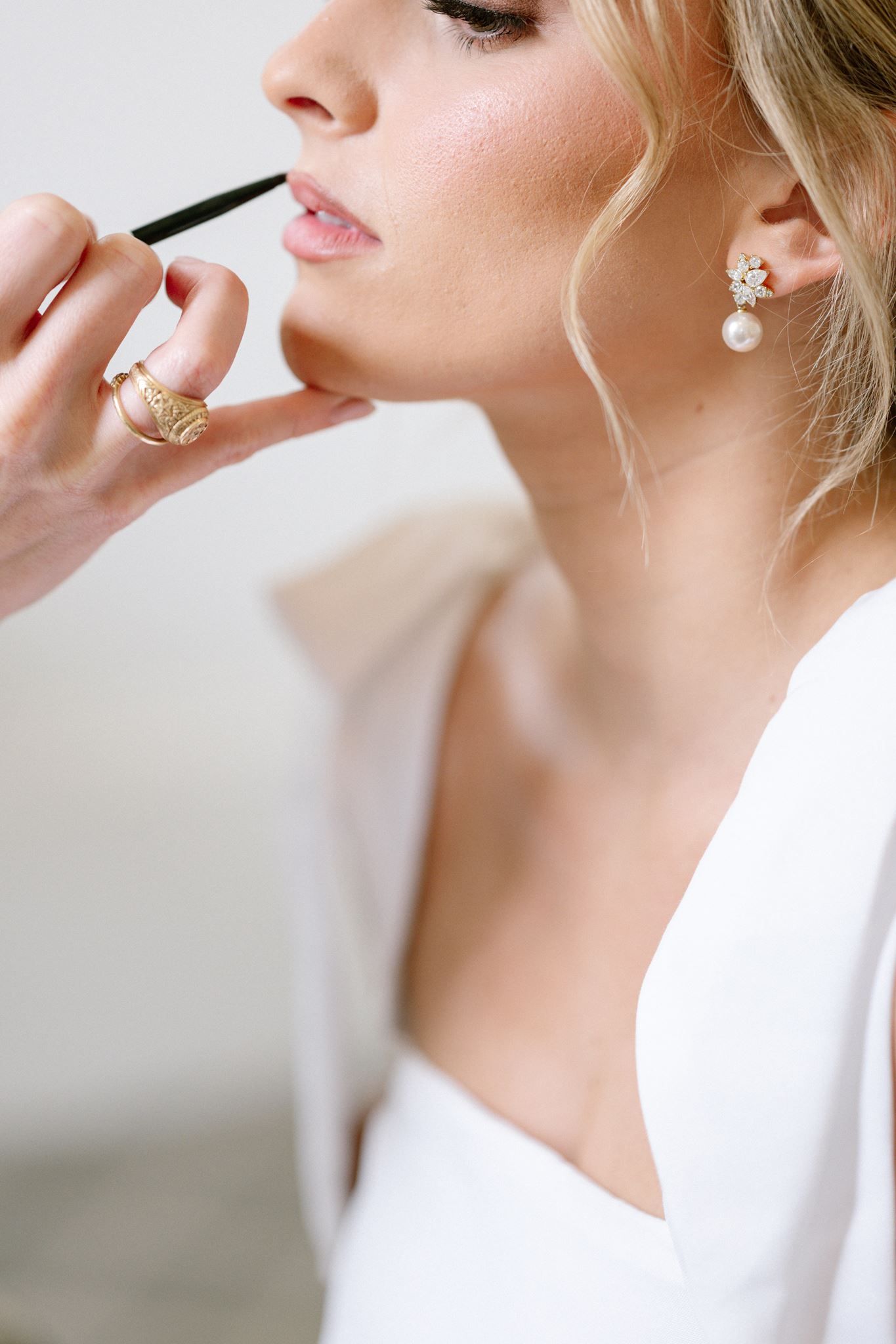 Close up of bride applying lipstick at Historic Hill House in Willis Texas.