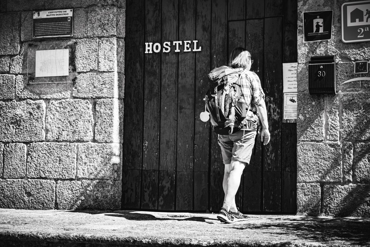 Cestovatel s batohem vstupuje do hostelu.