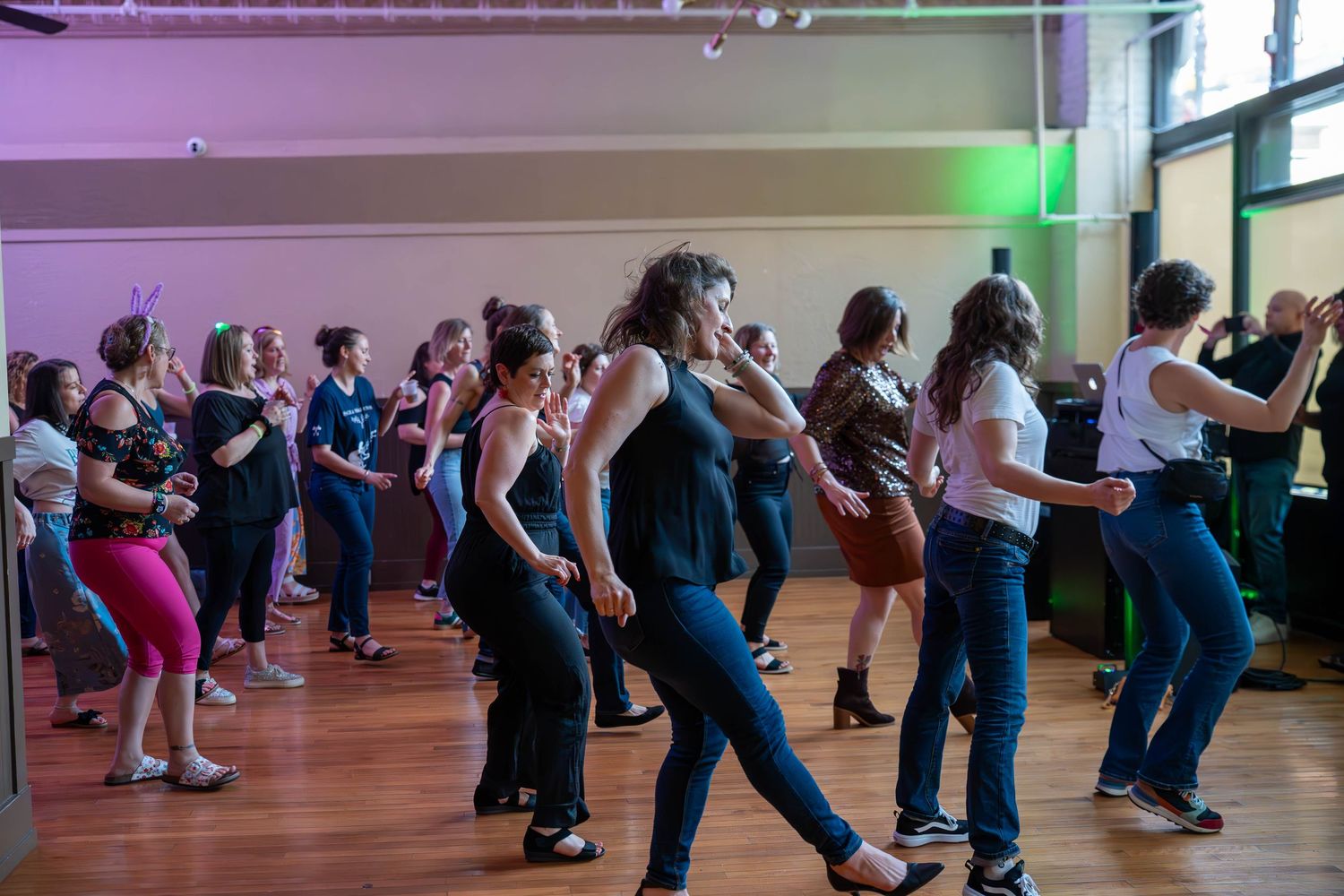Group of women dancing together in a bright studio during a lively dance class event.