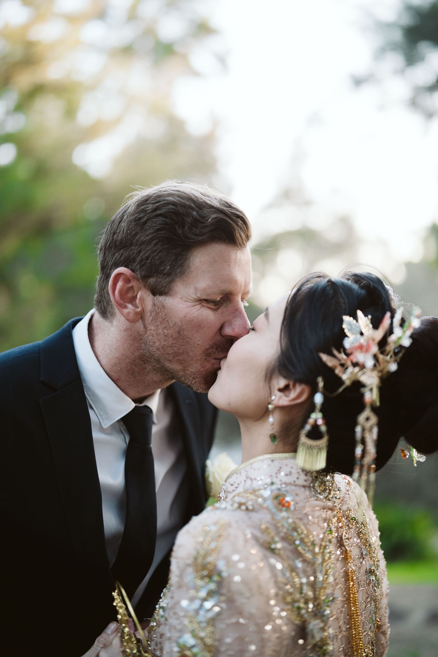 Cameron kissing Lulu on the cheek under the trees