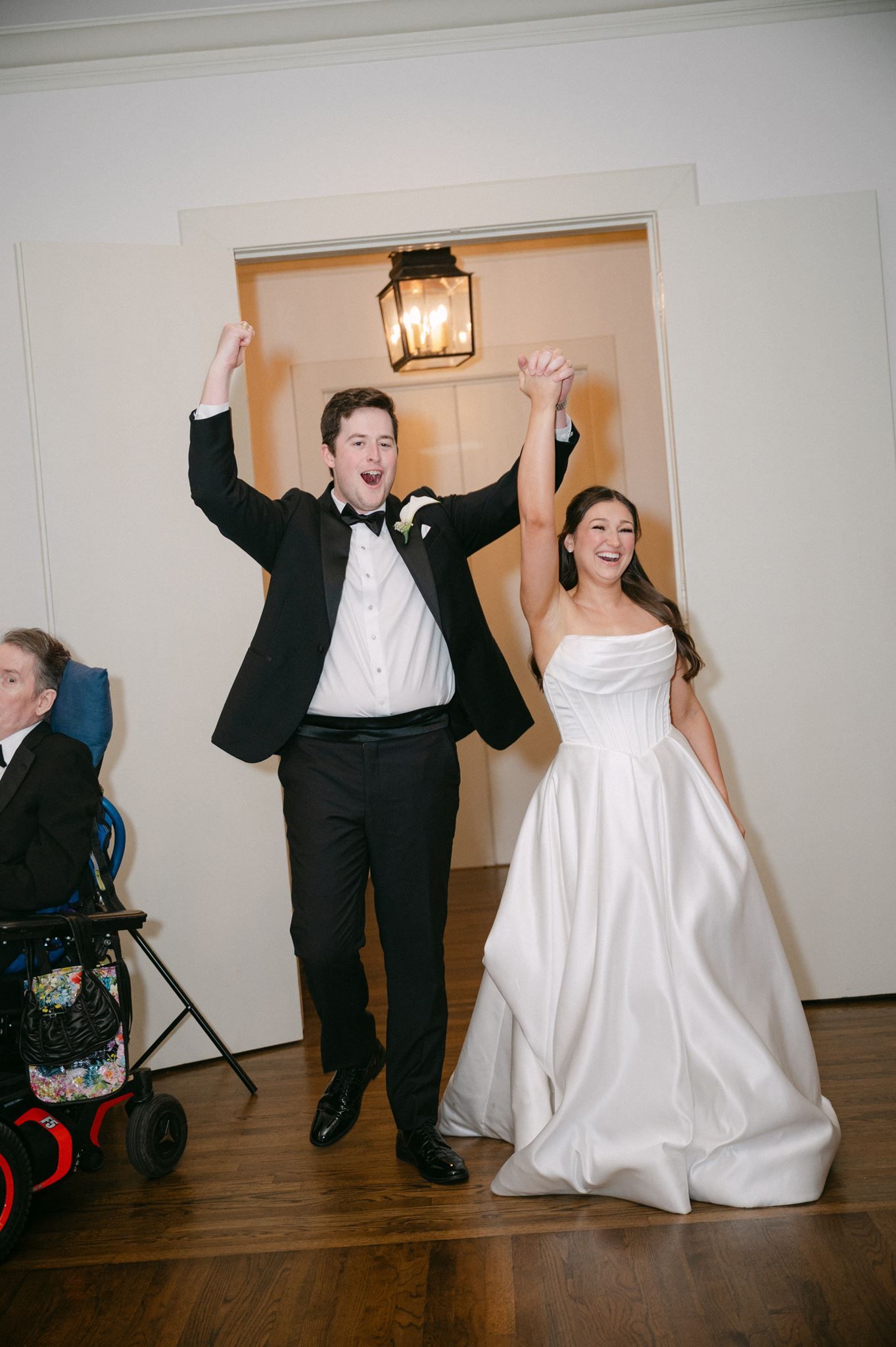 Bride and groom cheerfully entering reception space.