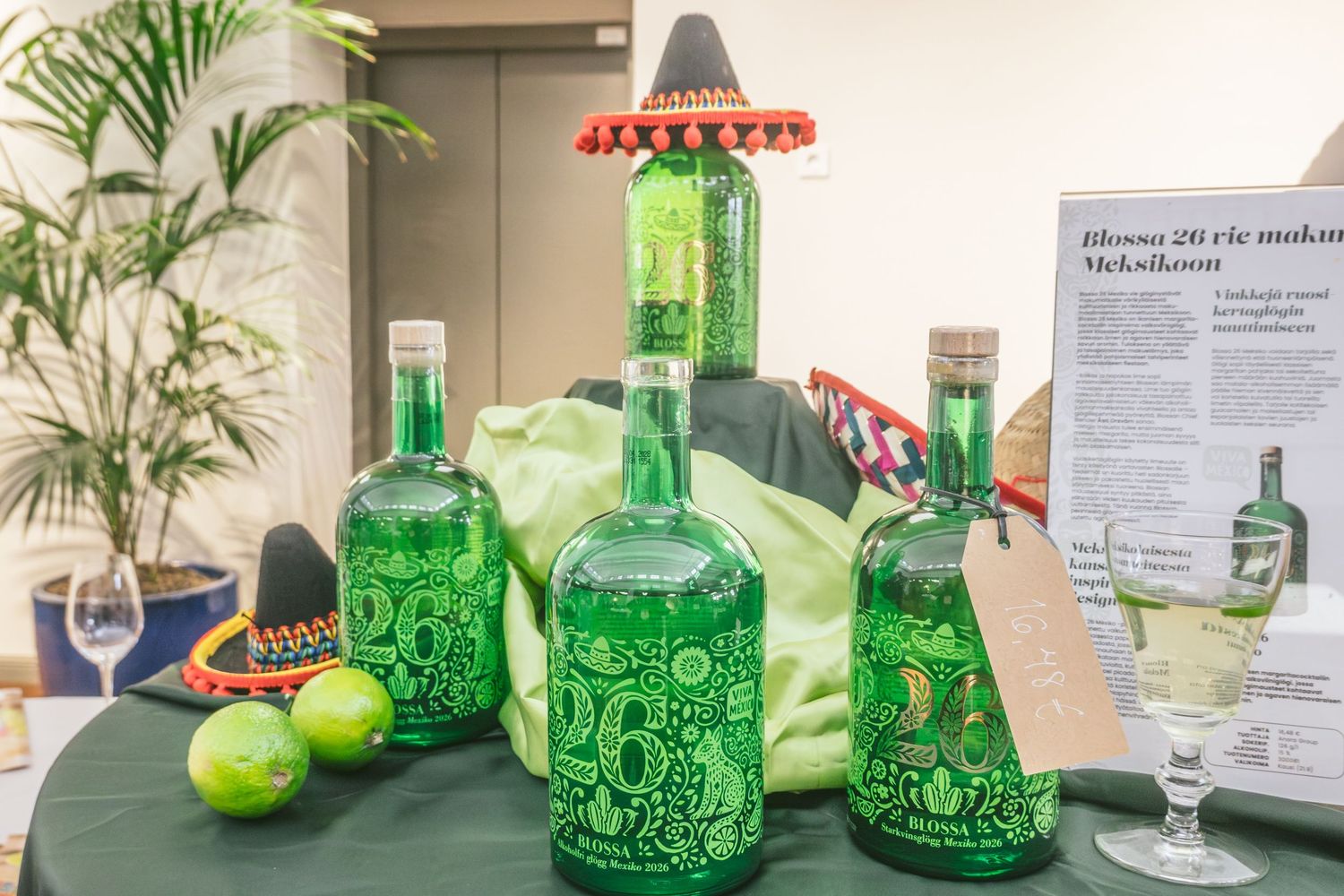 Blossa 26 Mexico glögg in its bright green bottle, presented with fresh limes at Helsinki Uncorked. Photo by © Reka Peurala Three Pod Studio