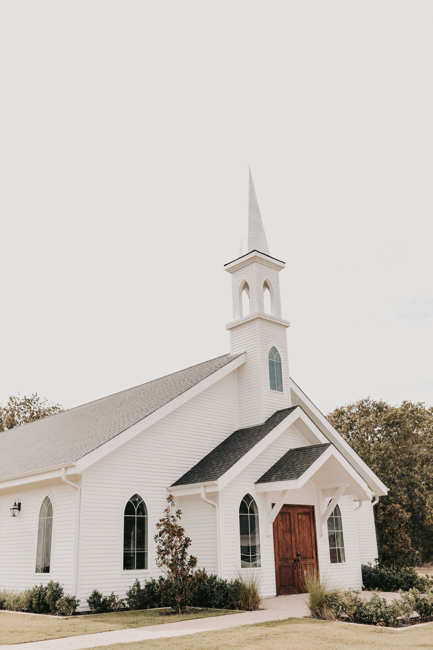 Interior of The White Sparrow chapel with wooden pews and romantic fall floral arrangements