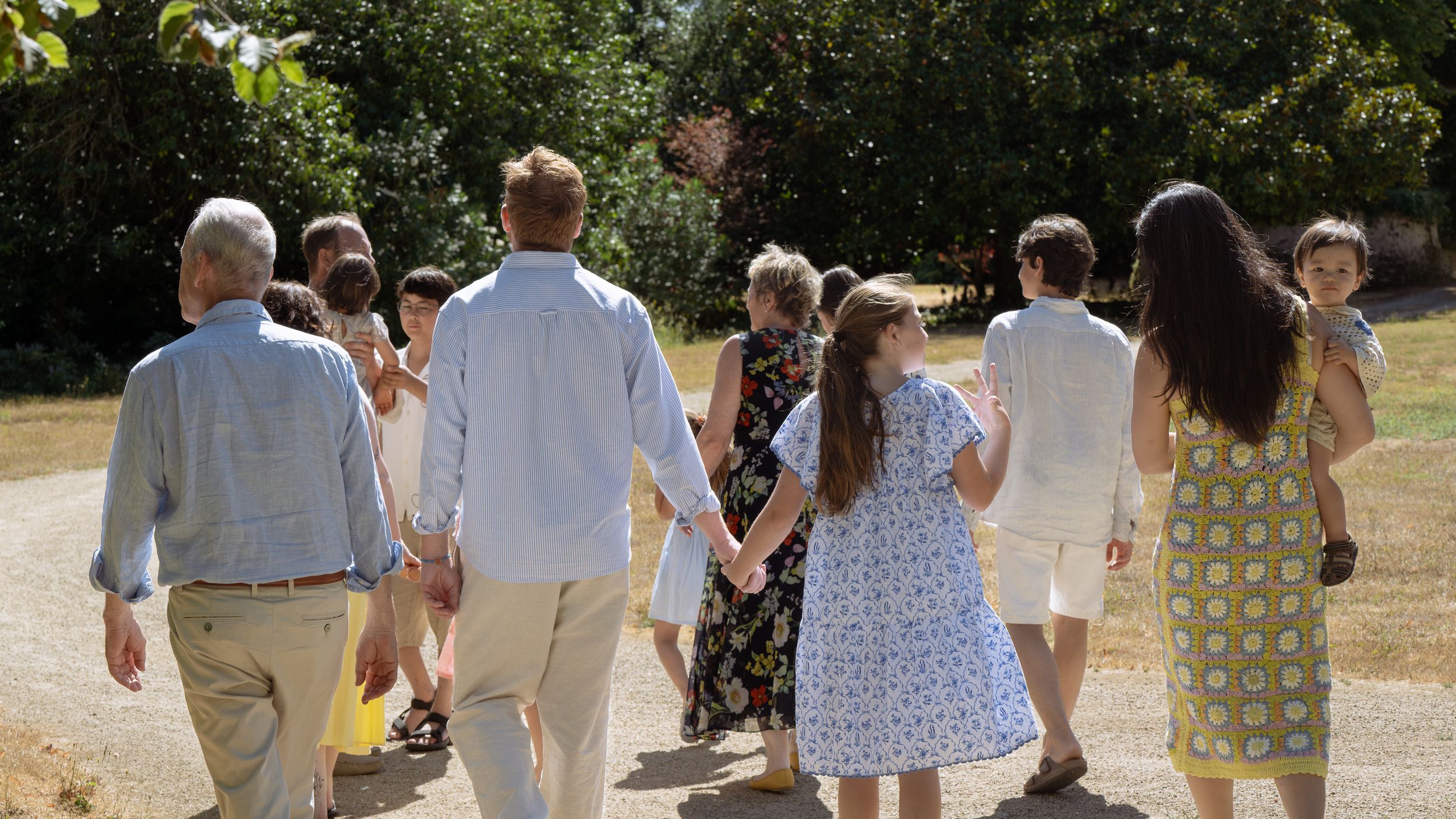 Une famille marchant ensemble dehors par une journée ensoleillée le long d'un sentier dans un château de Loire Atlantique