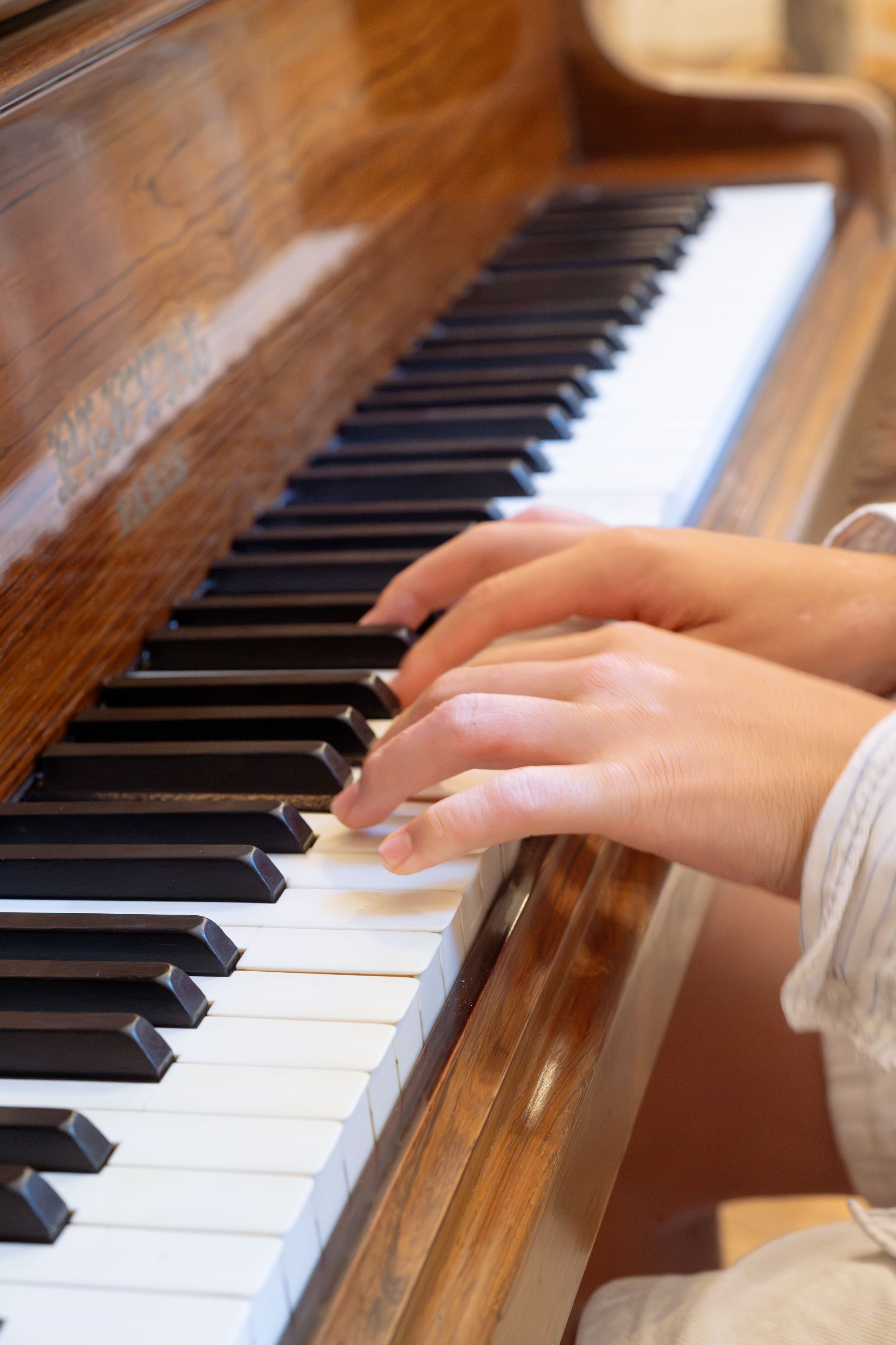 Des mains jouant sur un piano droit en bois, lors d'un anniversaire de mariage dans un Château de Loire Atlantique