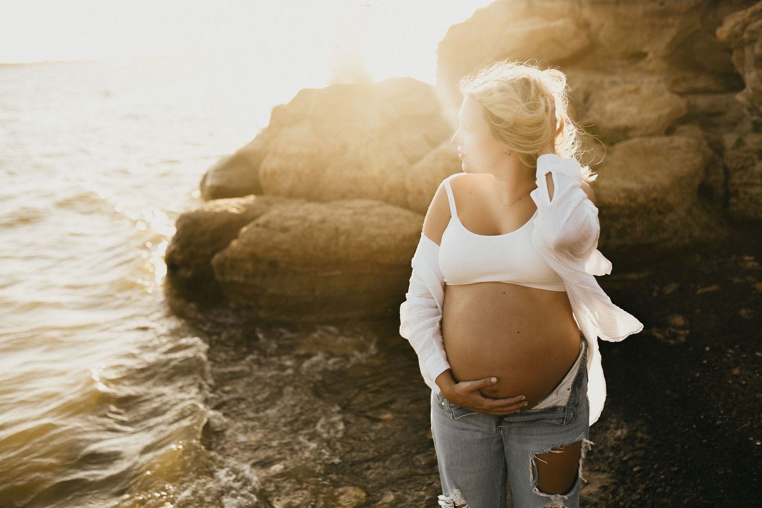 Expecting mom wearing a bandeau and linen overshirt for casual maternity photos
