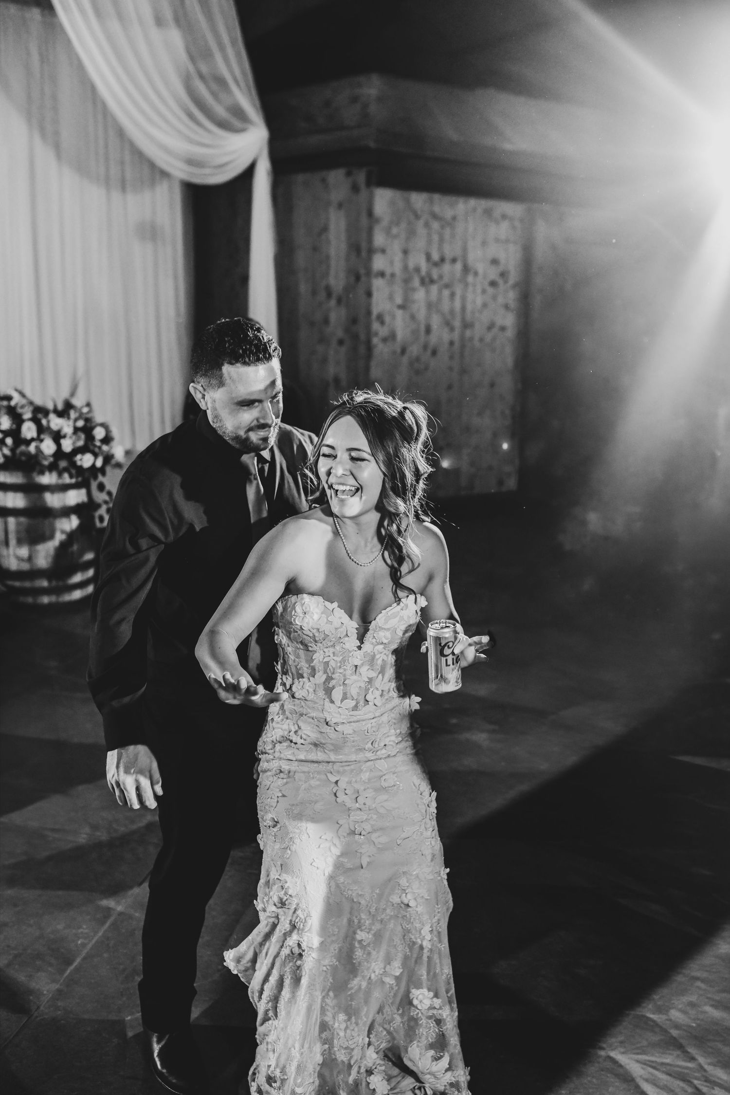 Newlyweds dancing beneath string lights during their ranch wedding