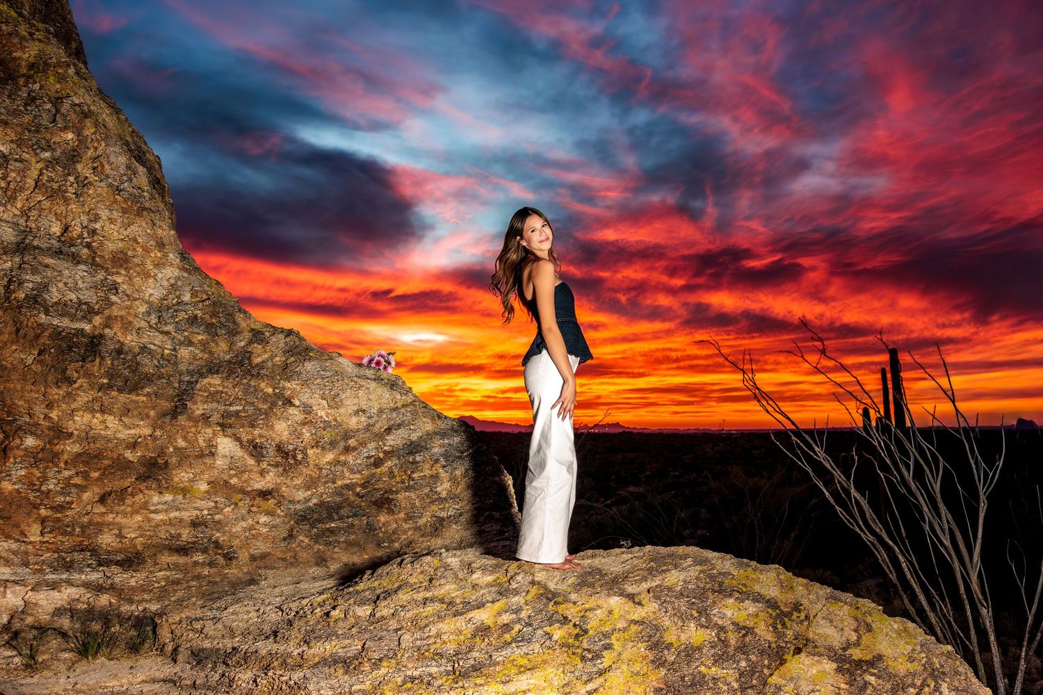 Senior girl on a cliff overlooking the beautiful Arizona sunset in Tucson