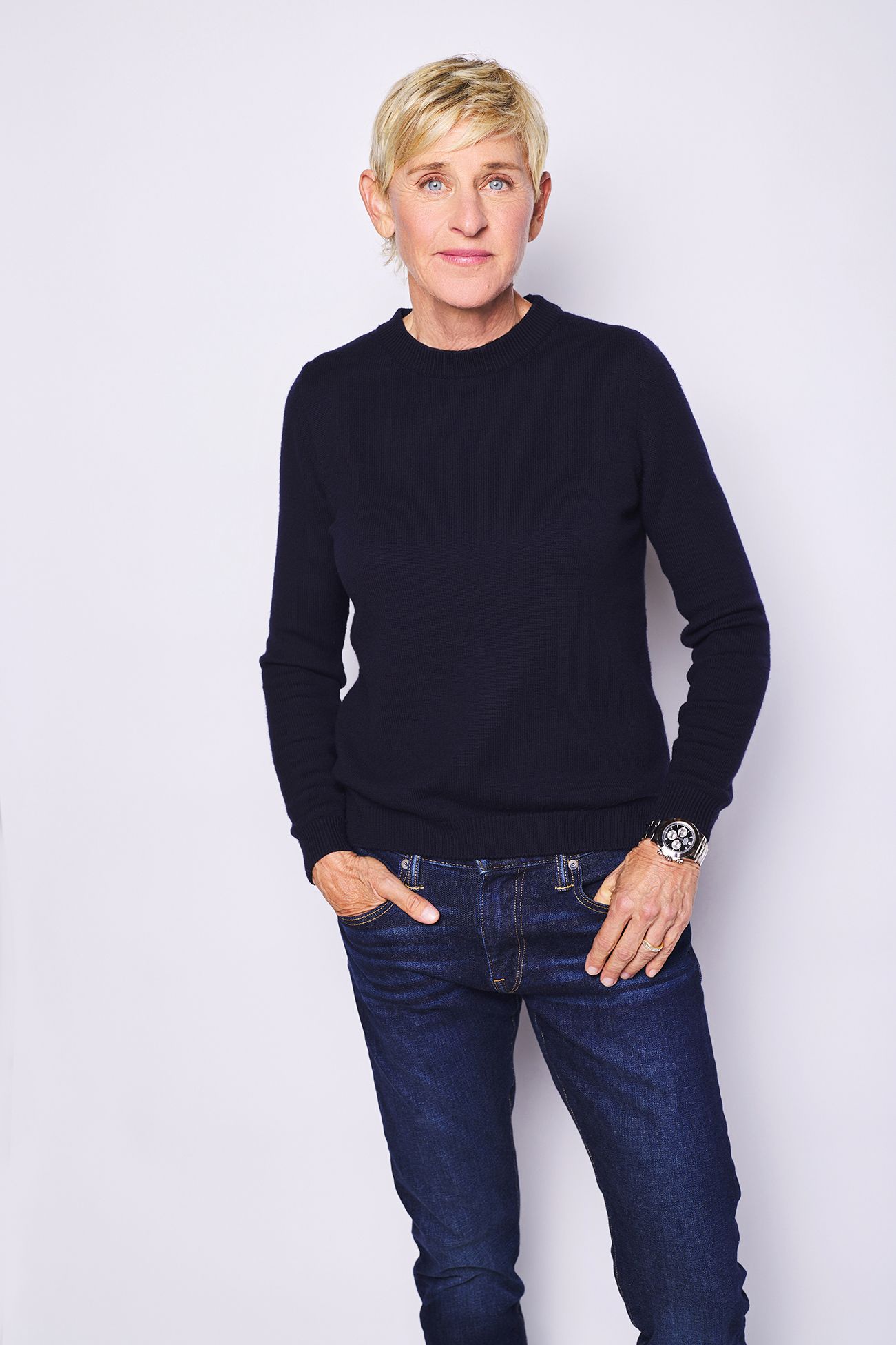 Ellen DeGeneres publicity photo wearing a navy sweater and jeans against a white background