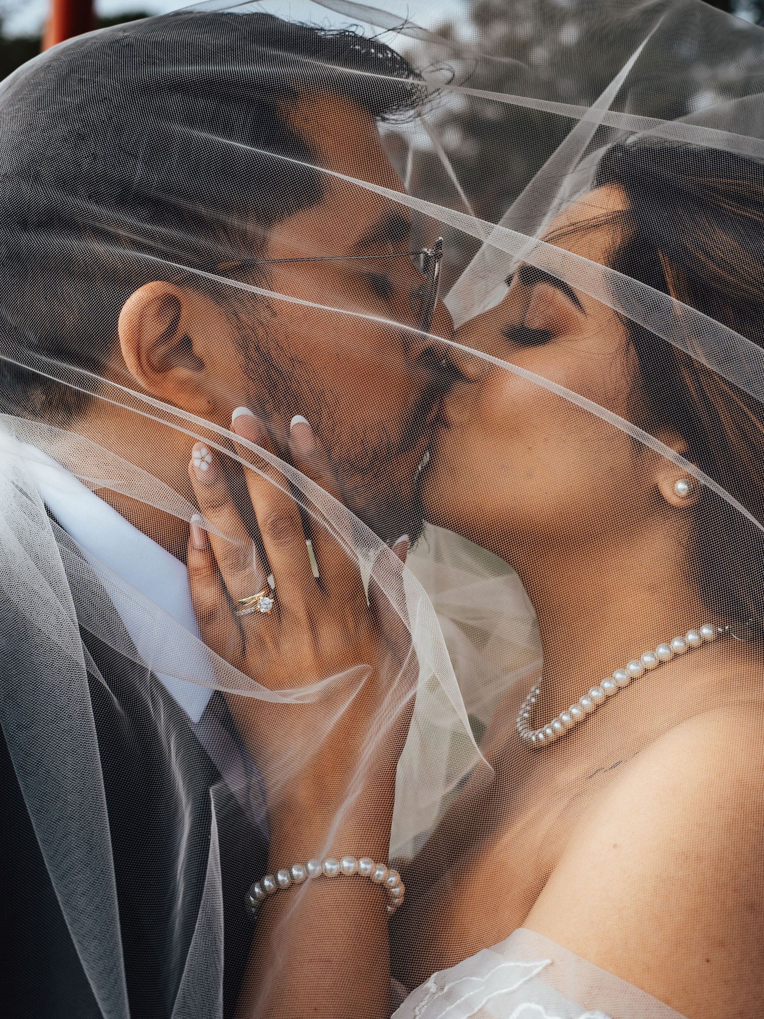 Romantic portrait of a bride and groom kissing beneath the veil during their wedding in Dundee, Scotland.