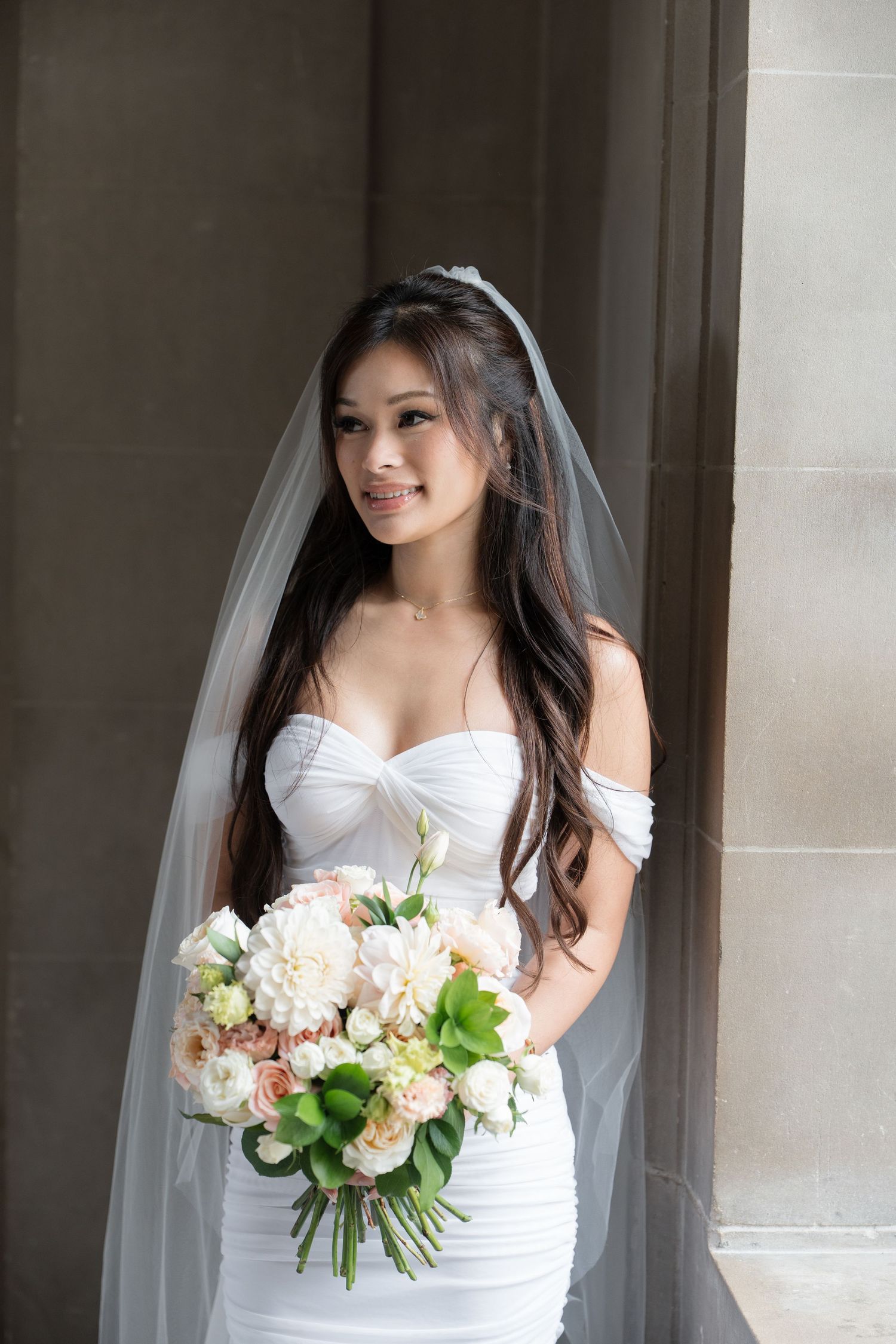 Bride and groom exchange vows at San Francisco City Hall, surrounded by grand marble columns and ornate balconies.