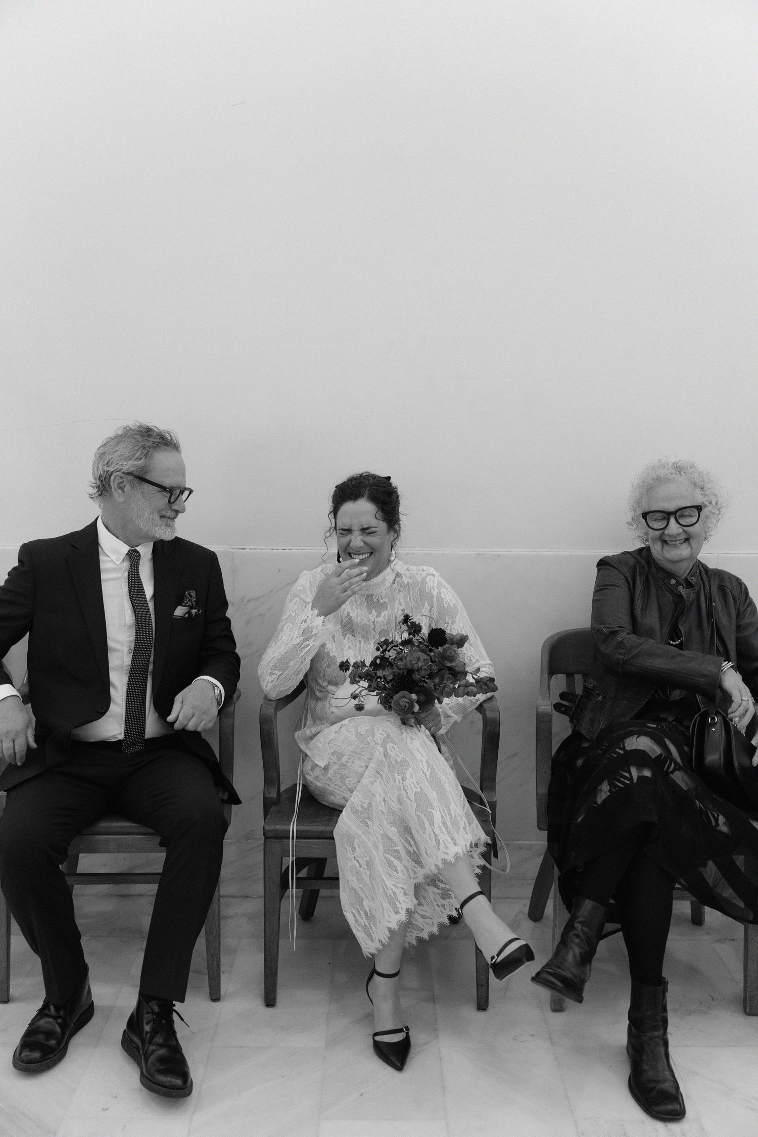 Black and white photo of a couple sharing their first kiss as newlyweds in an elegant San Francisco City Hall rotunda.