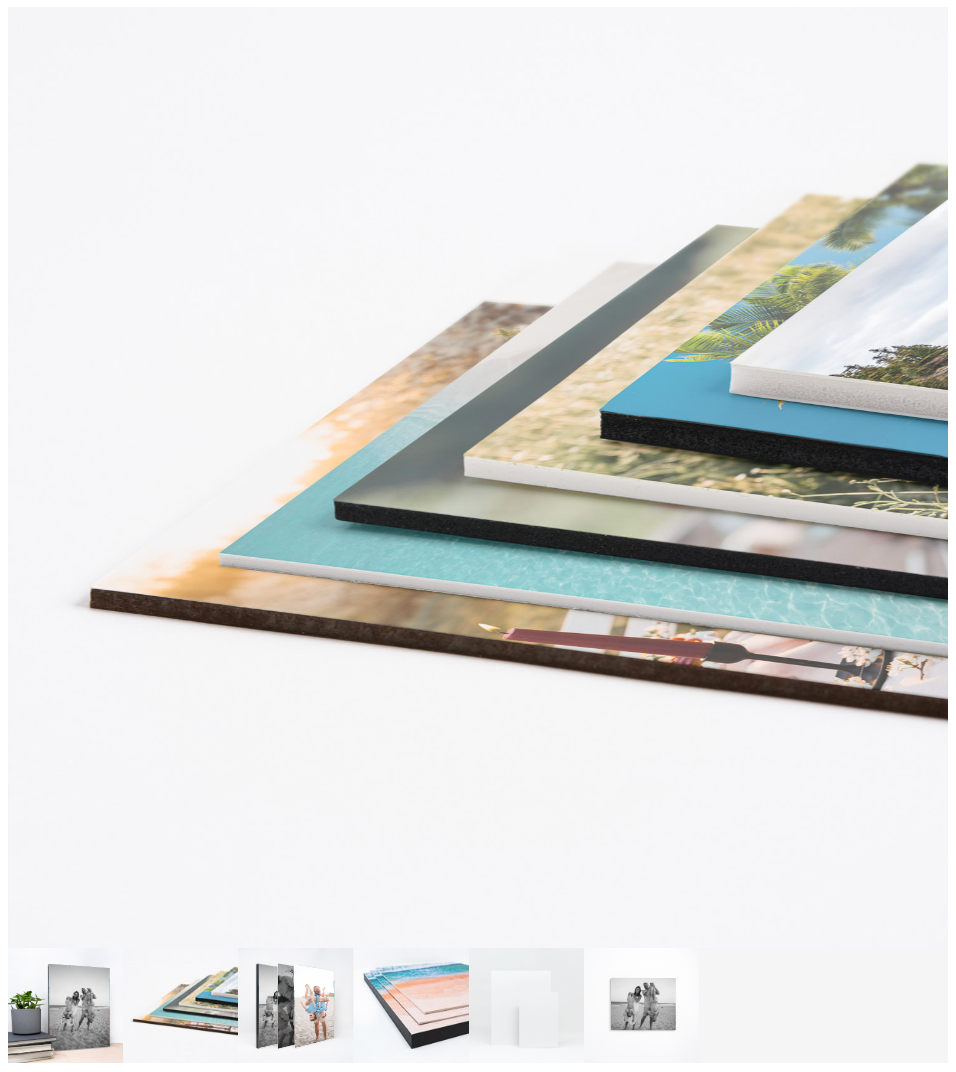 Stack of photo prints with vibrant landscape images, showcasing layered photography prints on a white surface.