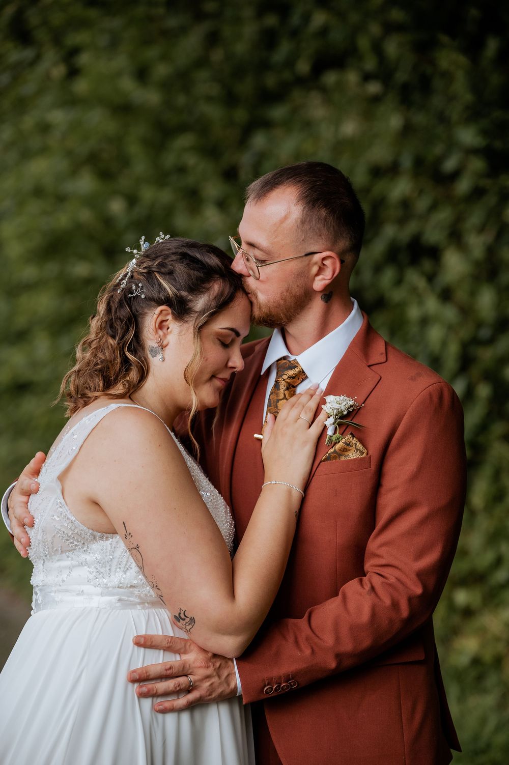 An emotional couple embraces during their outdoor wedding photo session.