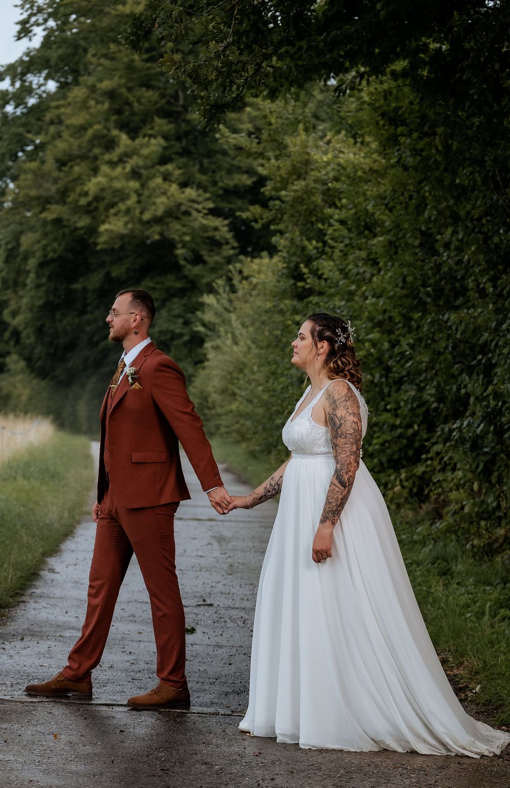 Playful wedding couple poses on gravel path showing dynamic movement and joy.
