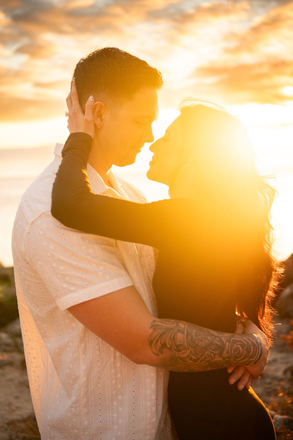 Newly engaged couple wrapped in golden sunset light along the shores of Clearwater Beach after a surprise proposal.