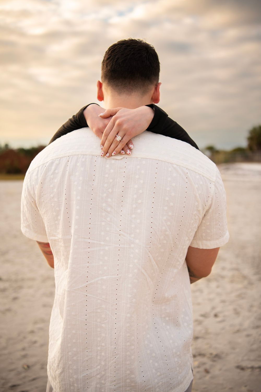 Engagement session in Clearwater FL showcasing a heartfelt beach proposal, the engagement ring and golden sunset portraits by the water.