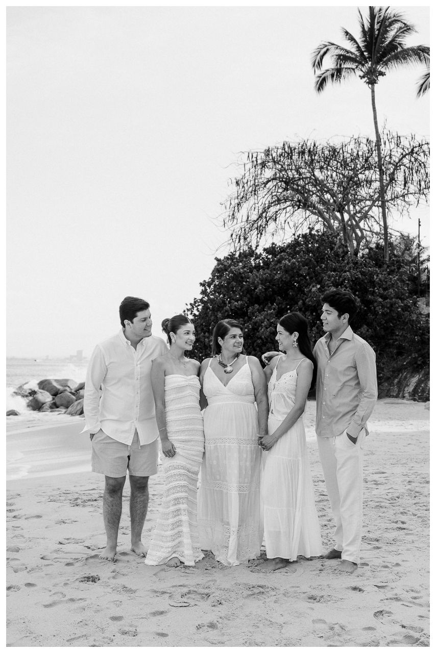 Puerto Vallarta Family Photographer captures Family Portraits on a sandy beach with palm trees and natural coastal surroundings.