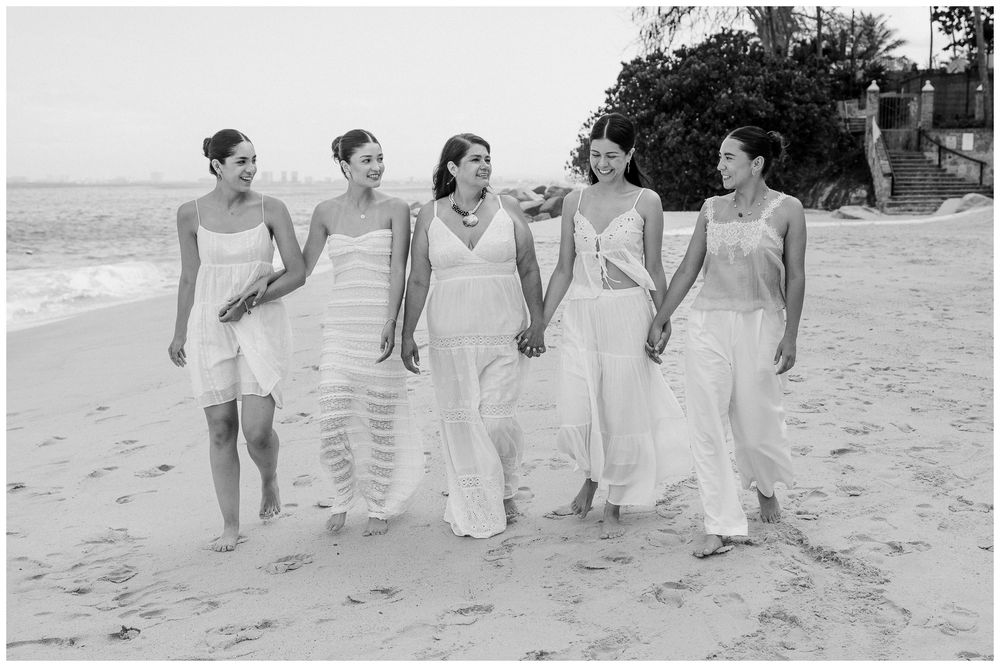 Puerto Vallarta Family Photographer captures Family Portraits of a mother and daughters walking together on a sandy beach while holding hand
