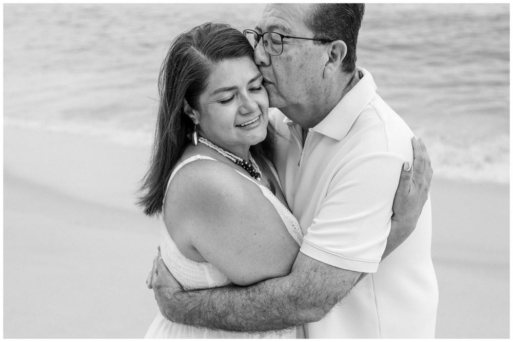 Puerto Vallarta Family Photographer captures Beach Family Photos of a couple embracing tenderly on a peaceful sandy beach.