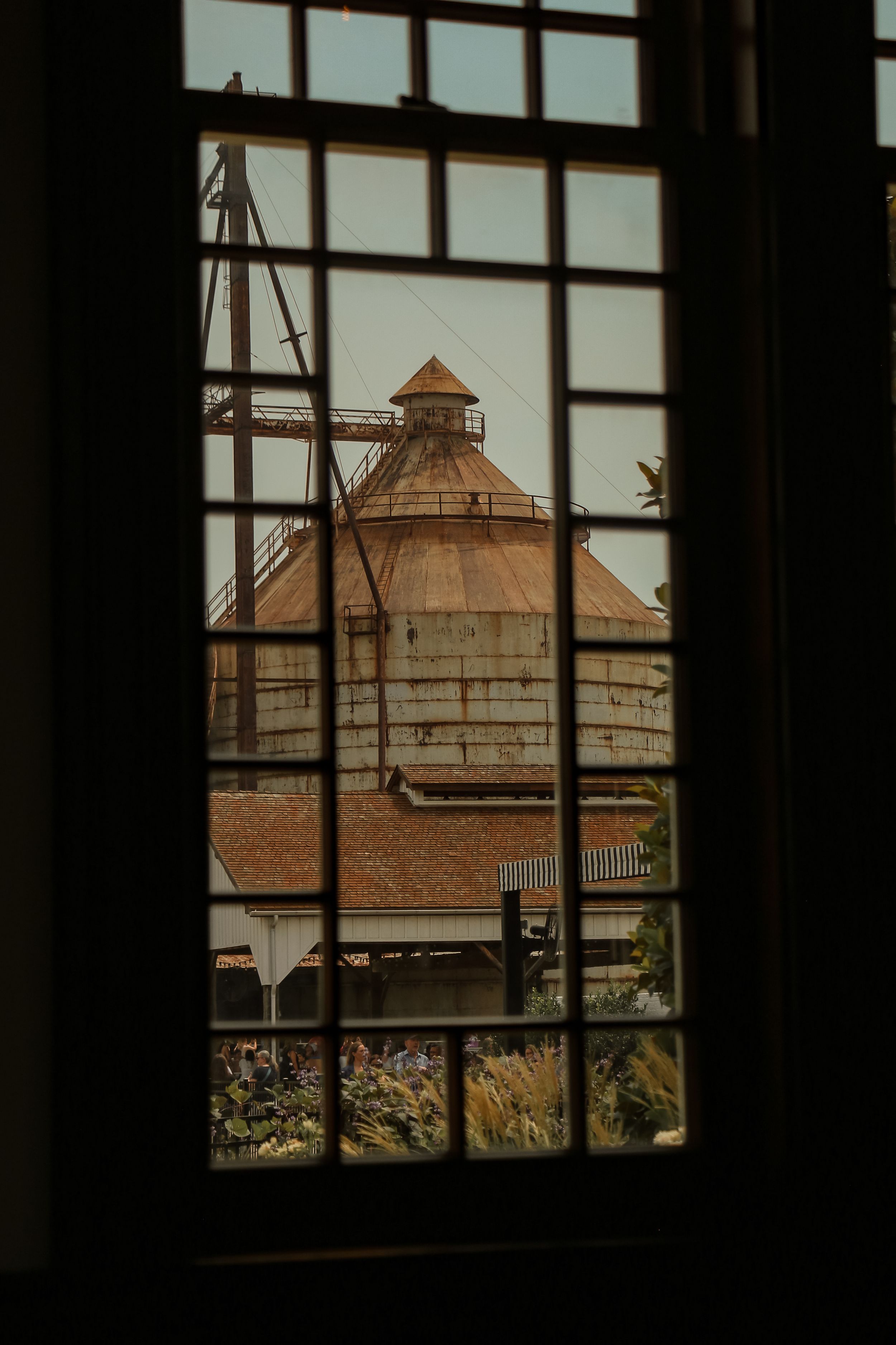 View of grain silo through windowpane grid pattern.