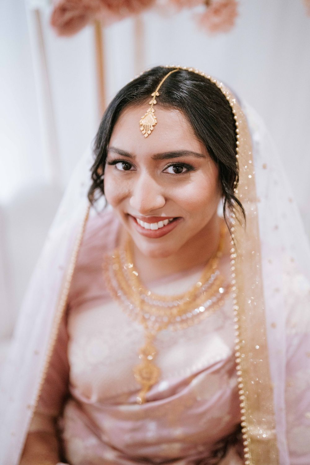 Bride portrait in pink saree and gold jewellery while getting ready for her Sydney Nikah