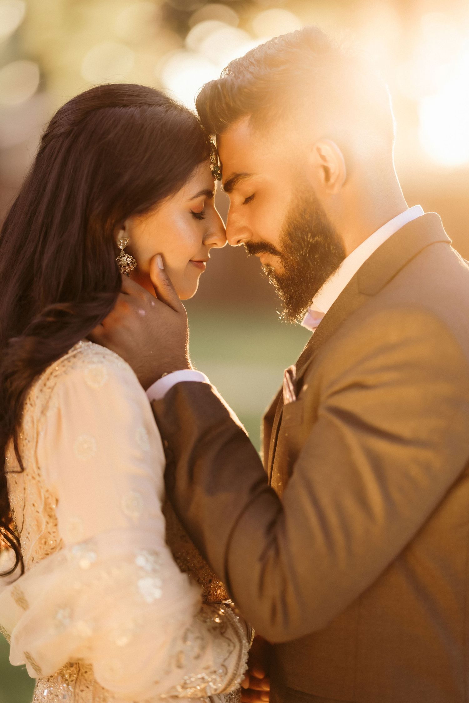 A couple shares an intimate moment in golden sunset light.