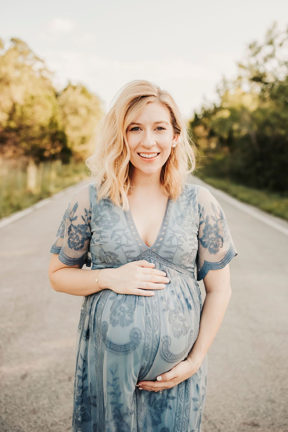 expectant mother posing joyfully during a sunset photoshoot.