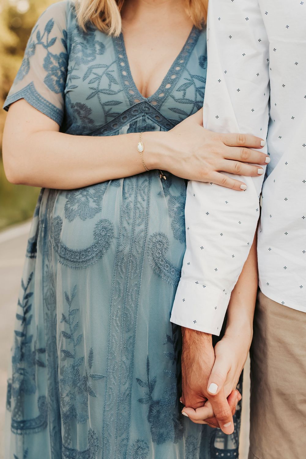 Maternity couple posing closely during a sunset photoshoot.
