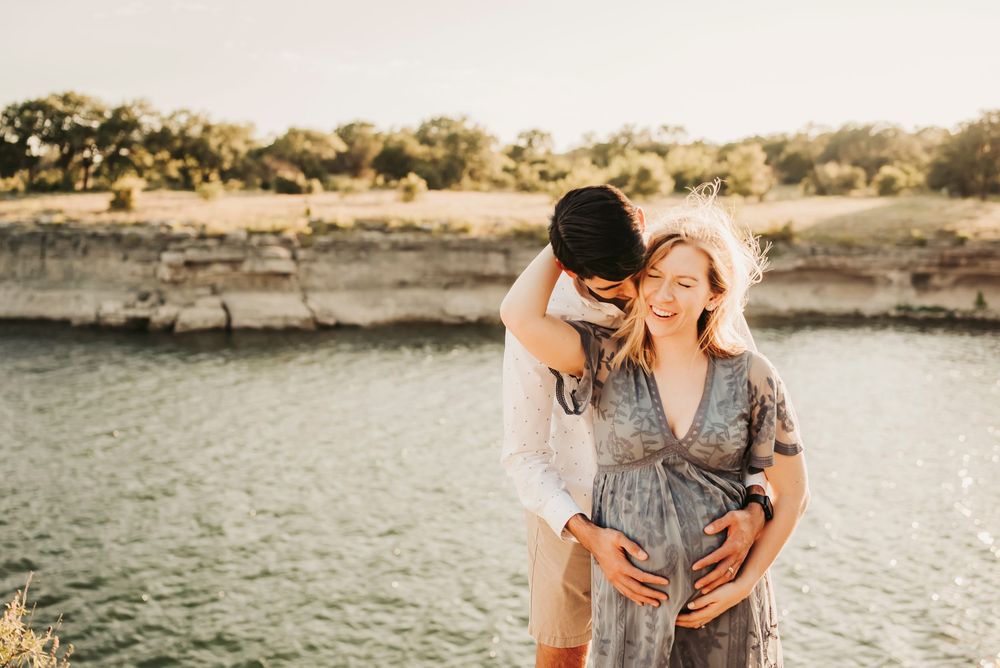 Father’s hands wrapped around mother’s belly during maternity session.