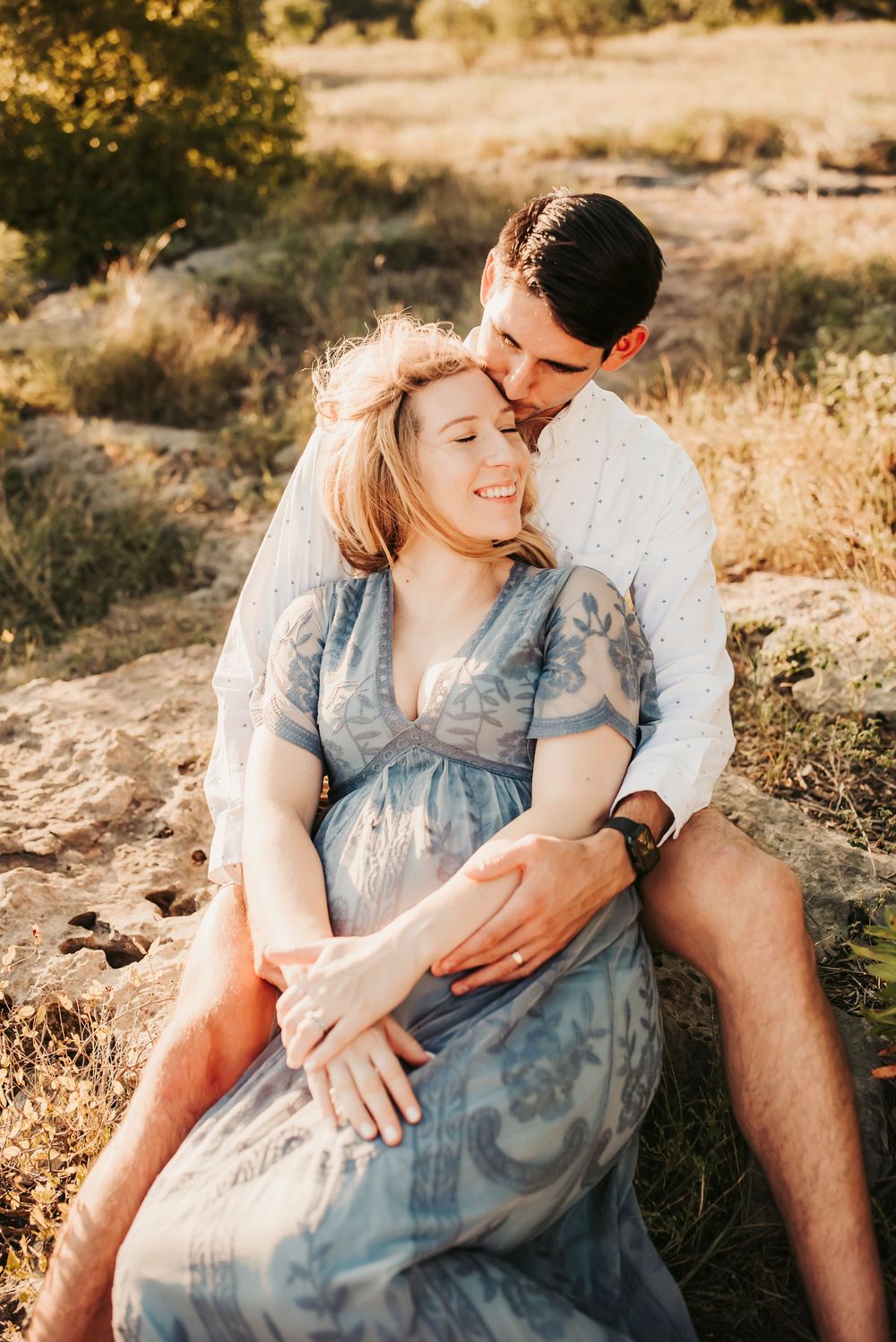 Maternity couple posing closely during a sunset photoshoot.