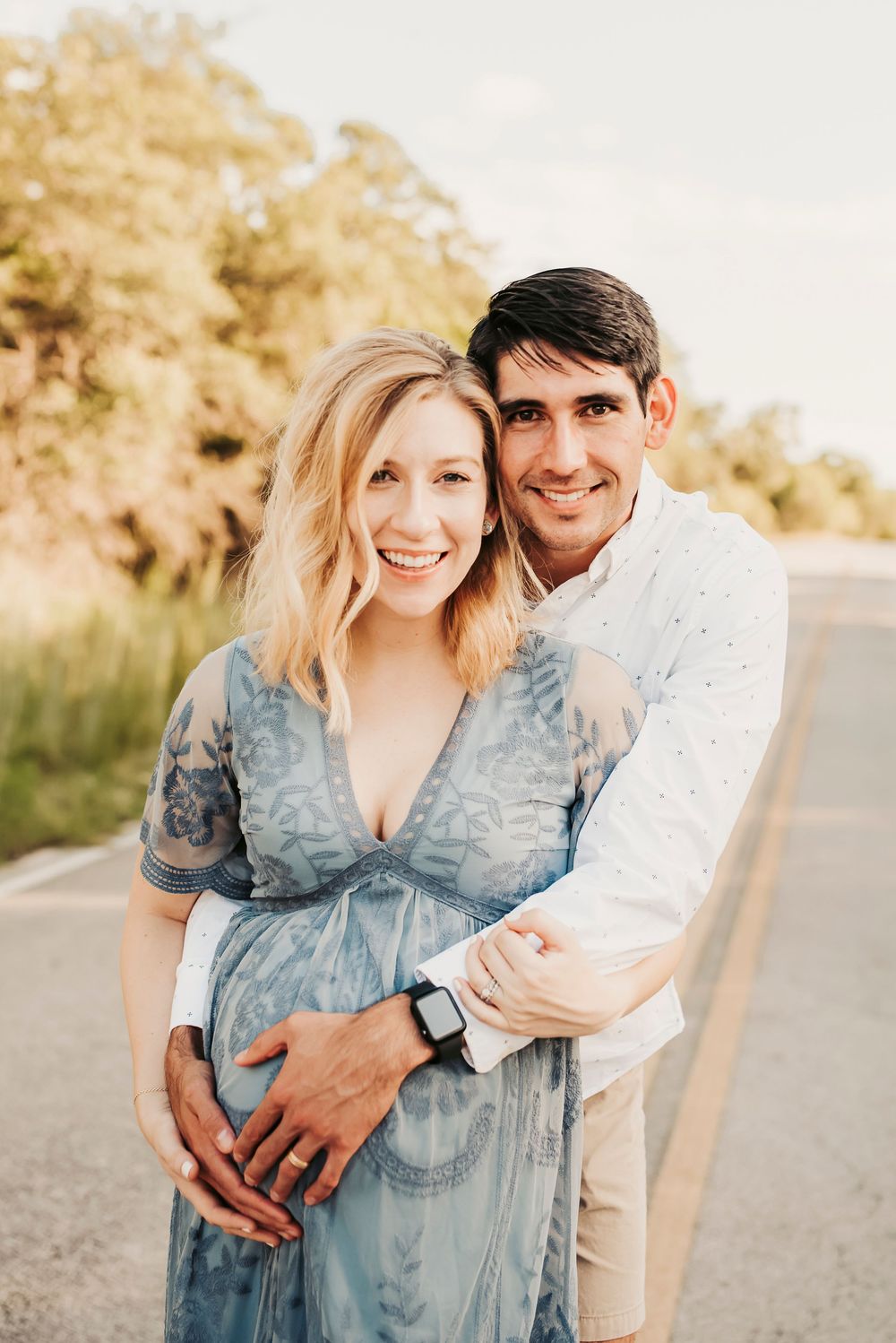 Father’s hands wrapped around mother’s belly during maternity session.