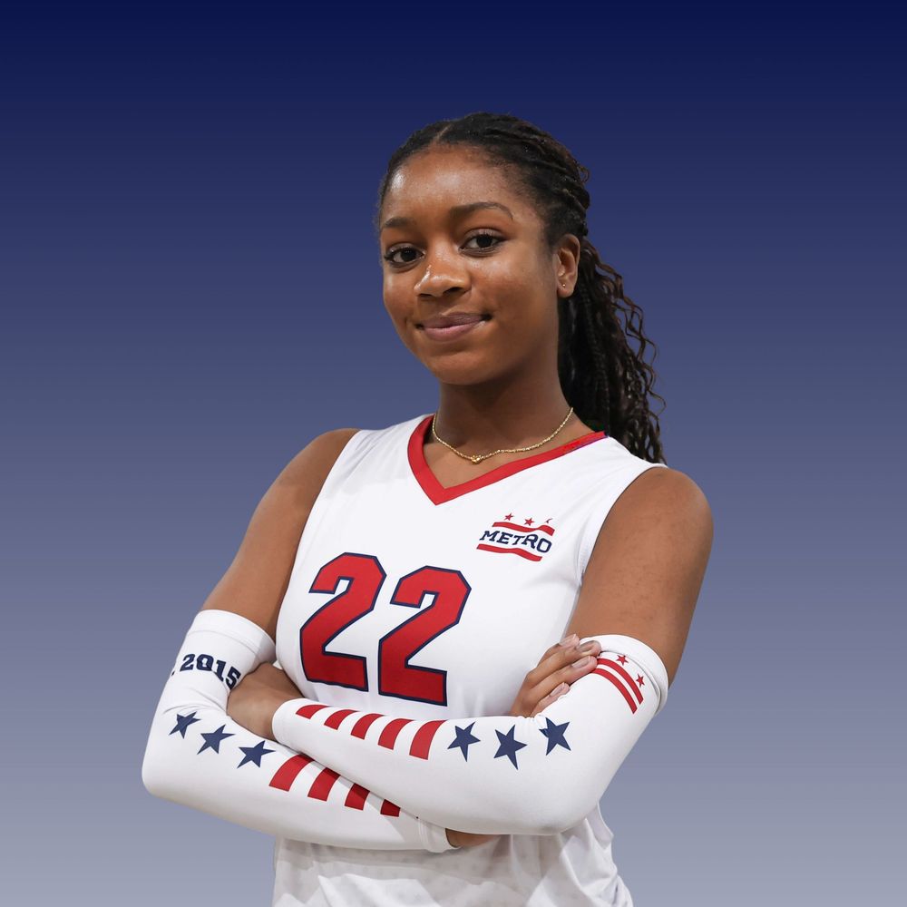 Basketball player in white and red uniform poses against blue gradient backdrop for professional sports photo shoot.